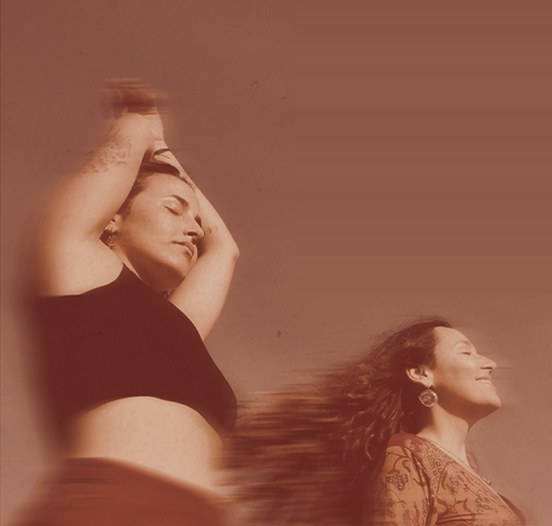 Two women dancing in warm light